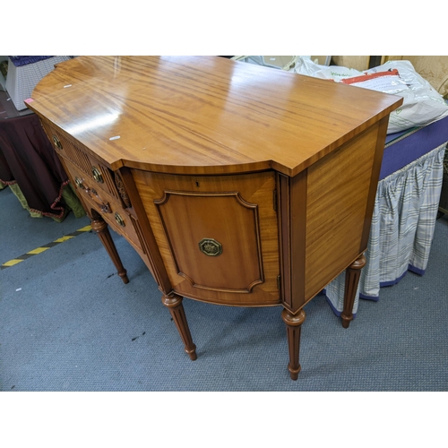 39 - A reproduction satinwood Regency inspired sideboard having two drawers flanked by cupboard doors, 91... 