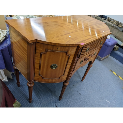 39 - A reproduction satinwood Regency inspired sideboard having two drawers flanked by cupboard doors, 91... 
