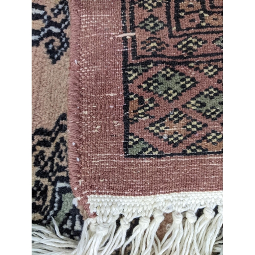 403 - A Middle Eastern handwoven rug having multiguard borders and repeating elephant foot motifs 186cm x ... 