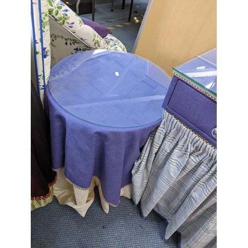 45 - A purple lined top dressing table with curtains below together with a pair of circular topped tables... 