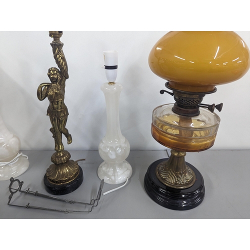 471 - A group of lamps to include two brass oil lamps with glass shades, a brass lamp in the form of a fig... 