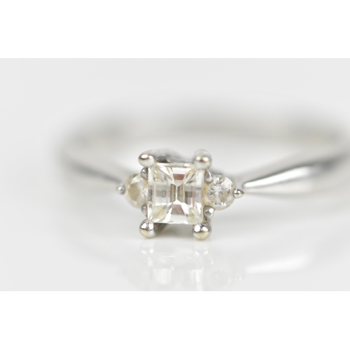 489 - An 18ct white gold and diamond engagement ring, with central princess style cut diamond with faceted... 