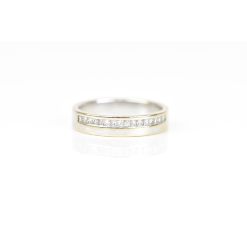 490 - An 18ct white gold and diamond wedding band, with a single row of princess cut channel set diamonds,... 