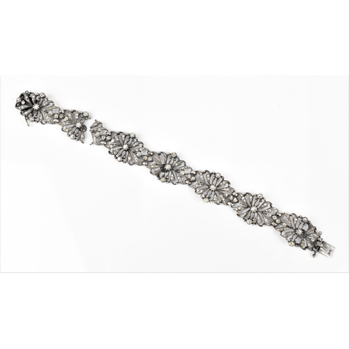 432 - An early 20th century Edwardian silver and paste bracelet, the floral openwork inset with paste thro... 