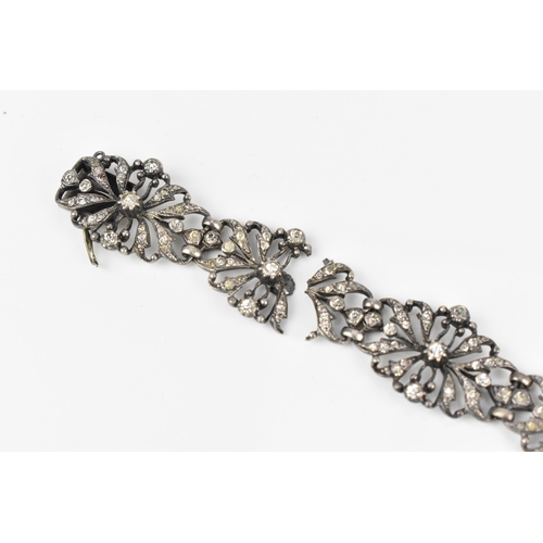 432 - An early 20th century Edwardian silver and paste bracelet, the floral openwork inset with paste thro... 