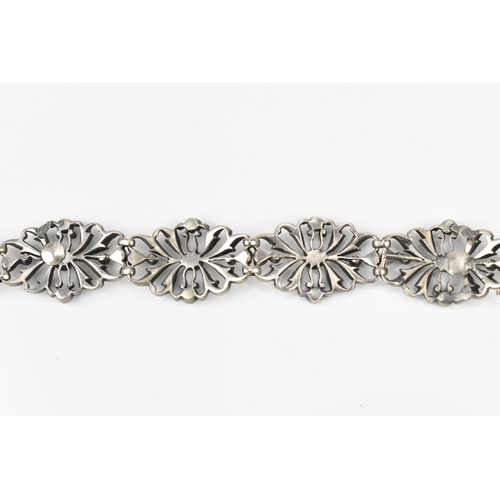 432 - An early 20th century Edwardian silver and paste bracelet, the floral openwork inset with paste thro... 