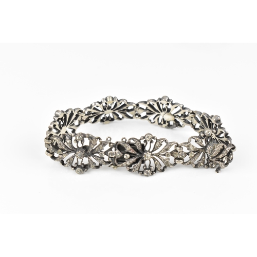 432 - An early 20th century Edwardian silver and paste bracelet, the floral openwork inset with paste thro... 