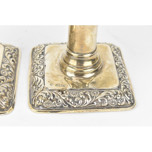 434 - A set of four Edwardian silver candlesticks by William Hutton & Sons, Birmingham 1906, with embossed... 