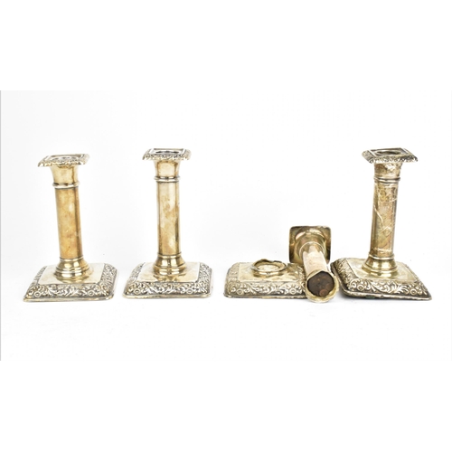 434 - A set of four Edwardian silver candlesticks by William Hutton & Sons, Birmingham 1906, with embossed... 