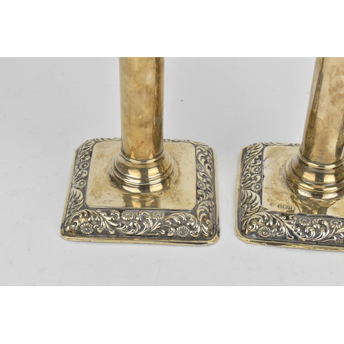 434 - A set of four Edwardian silver candlesticks by William Hutton & Sons, Birmingham 1906, with embossed... 