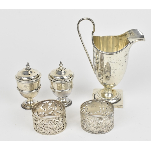 438 - A small collection of silver, to include an Edwardian silver milk jug, a pair of Victorian pepper po... 