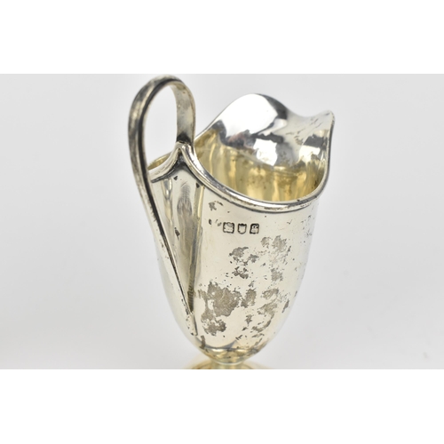 438 - A small collection of silver, to include an Edwardian silver milk jug, a pair of Victorian pepper po... 