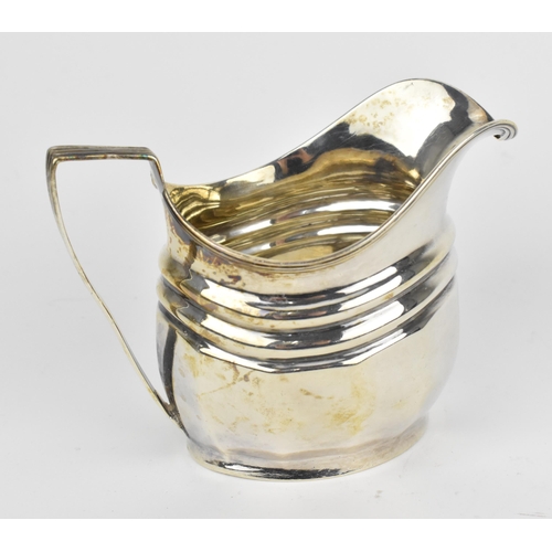 439 - A George III silver milk jug, London 1804, with reeded handle and faceted body, 8.6 cm high, weight ... 