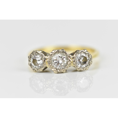 441 - An 18ct yellow and white gold diamond three stone ring, set with three brilliant cut diamonds illusi... 