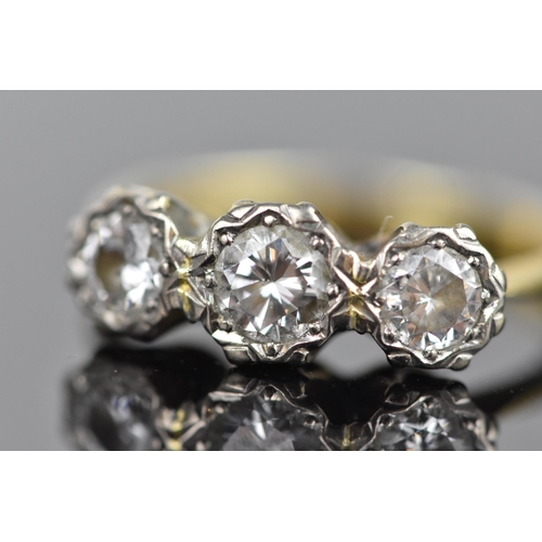 441 - An 18ct yellow and white gold diamond three stone ring, set with three brilliant cut diamonds illusi... 