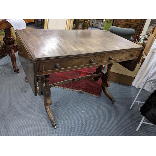 469 - A Regency mahogany sofa table having two drawers, turned supports and on four splayed legs, 73.5cm h... 