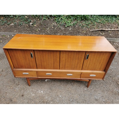 300 - A mid-century G-plan teak 'fresco' sideboard, with two folding doors each enclosing a shelf, over th... 