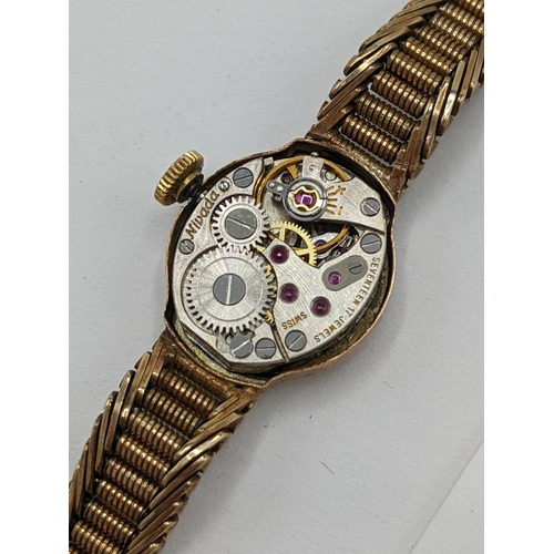 57 - A Nivada manual wind ladies 9ct wristwatch, having a white enamel dial with baton markers, the 17 je... 