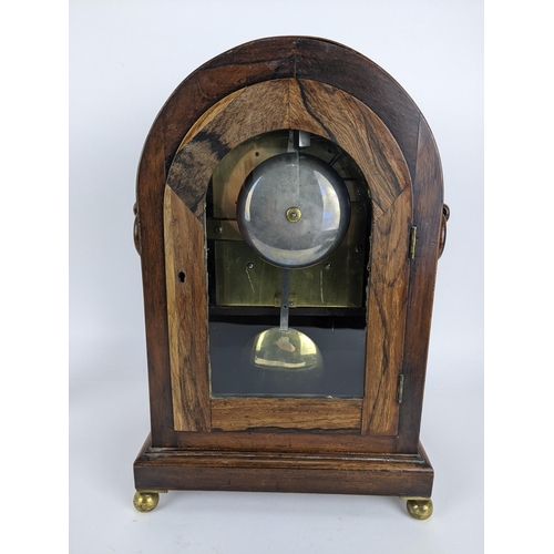 68 - A Regency rosewood bracket clock having an arched top, two ring handles, pierced grilles to both sid... 