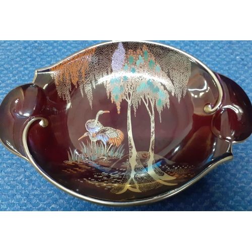 209 - A Carlton ware 'Rouge Royale' brown lustre dish depicting two herons under trees together with a bis... 