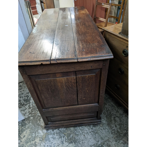 265 - A 19th century oak farmhouse deep wooden chest, panelled front, sides and back, two base drawers, ov... 