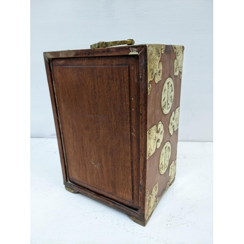 353 - A Chinese wooden and brass mounted desk cabinet, twin doors revealing four internal drawers and one ... 