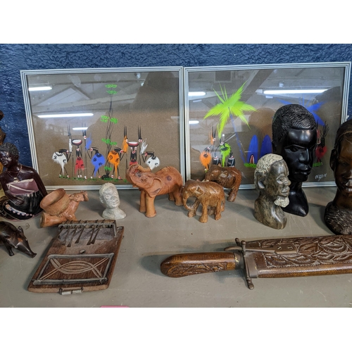 45 - A collection of African carved wooden busts, musical instruments, spears, some with beaded decoratio... 