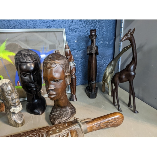 45 - A collection of African carved wooden busts, musical instruments, spears, some with beaded decoratio... 