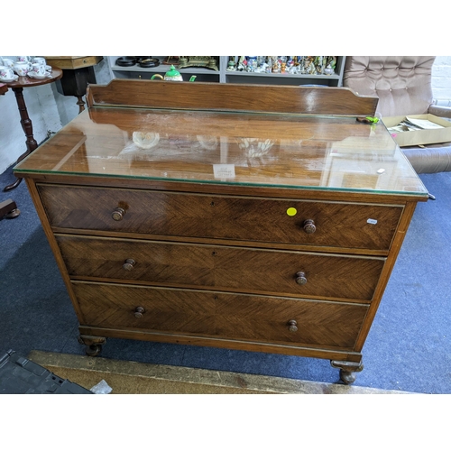 280 - A mid 20th century walnut chest of three long drawers having a raised back and on short cabriole fee... 