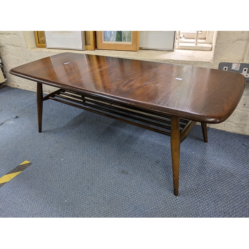 460 - A mid 20th century Ercol stained elm and beech coffee table with magazine rack below, 36cm h x 105cm... 