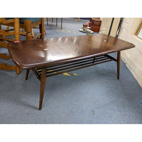 460 - A mid 20th century Ercol stained elm and beech coffee table with magazine rack below, 36cm h x 105cm... 