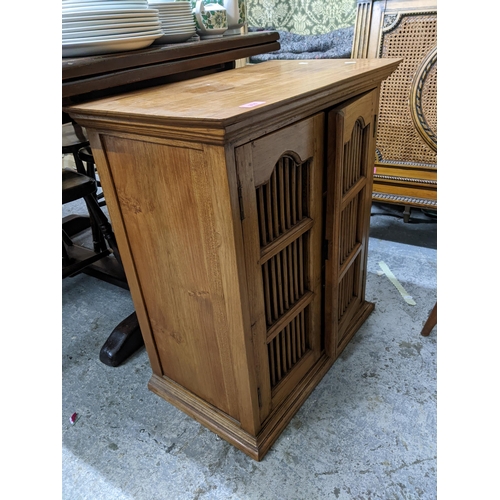 374 - A teak side cabinet with twin grill doors on plinth base 70cm x 64cm x 37cm Location: G