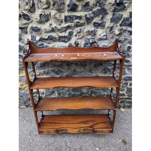 469 - An early 20th century mahogany wall hanging shelf unit, four open shelves with three base drawers 92... 