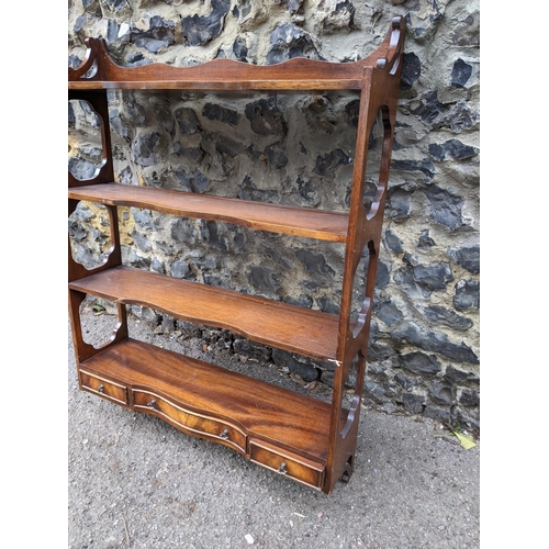 469 - An early 20th century mahogany wall hanging shelf unit, four open shelves with three base drawers 92... 