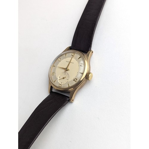 64 - A Garrard gents 9ct gold cased manual wind wristwatch, having a silvered dial with Arabic numerals, ... 