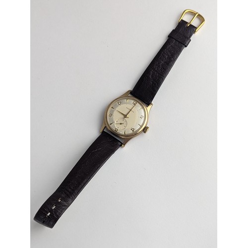64 - A Garrard gents 9ct gold cased manual wind wristwatch, having a silvered dial with Arabic numerals, ... 