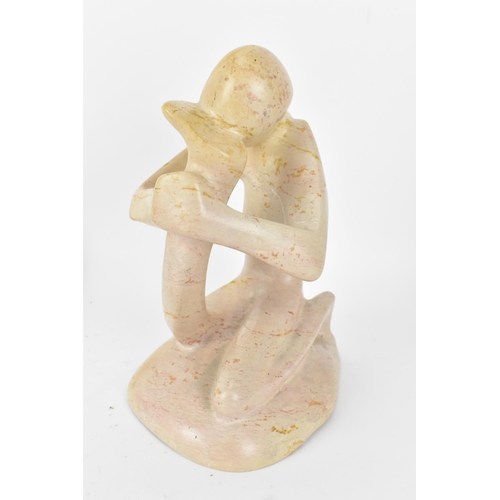 203 - Two African soapstone figural sculptures, one modelled as a man holding his foot to his head, the ot... 
