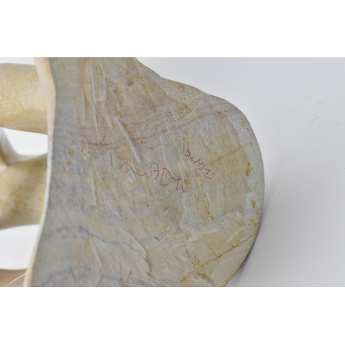 203 - Two African soapstone figural sculptures, one modelled as a man holding his foot to his head, the ot... 