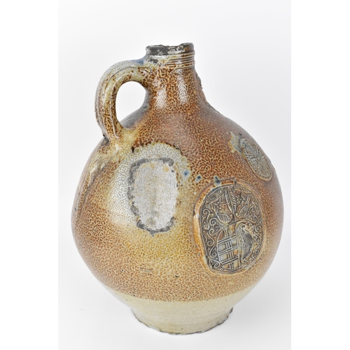 208 - A large German stoneware armorial Bellarmine, salt glazed, the mask with elongated beard above the o... 