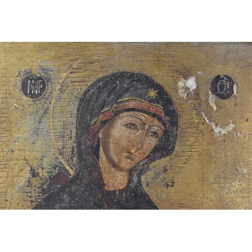 216 - A 19th century Russian icon of The Mother of God, with Cyrillic letters either side of her, tempura ... 