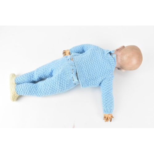220 - A French S.F.B.J bisque headed doll, with blue glass eyes, and articulated elbows and knees, clothed... 
