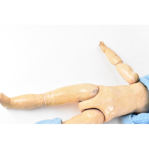 220 - A French S.F.B.J bisque headed doll, with blue glass eyes, and articulated elbows and knees, clothed... 