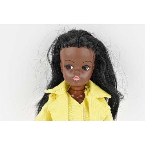215 - A vintage Sindy's friend Gayle doll in a yellow pant suit, with additional black mules, with painted... 