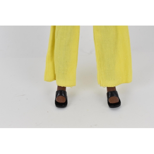 215 - A vintage Sindy's friend Gayle doll in a yellow pant suit, with additional black mules, with painted... 