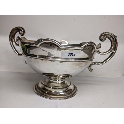 1 - An early 20th century silver twin handled bowl having scroll shaped handles, scalloped rim and a ste... 