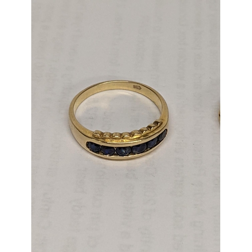 11 - Two gold rings, one stamped 585 set with blue sapphires, together with a 10k stamped ring with colou... 