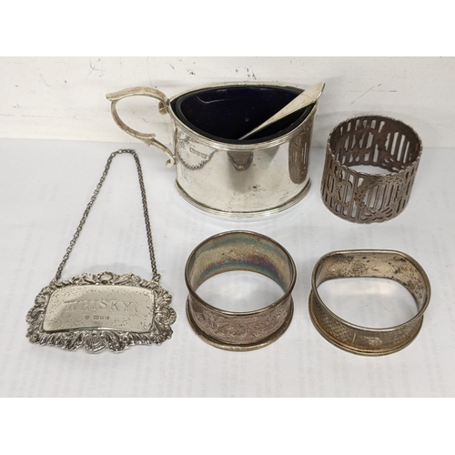 38 - Mixed silver to include a whiskey label, napkin rings, mustard pot and spoons, 136.8g
Location: TABL... 