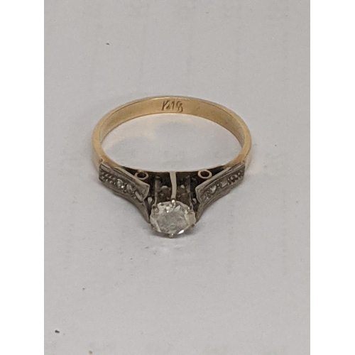 56 - A yellow and white metal diamond ring with diamond chip shoulders testing as 18 ct 3.7g ring size R/... 