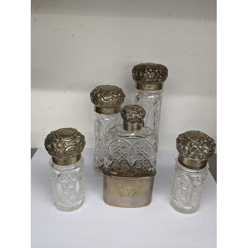 58 - Victorian silver and glass dressing table items to include four embossed jars and a matching hip fla... 