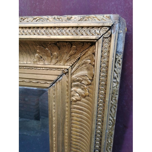 195 - A 19th century French gilt-wood and gesso mirror, with rectangular beveled plate in a moulded frame ... 